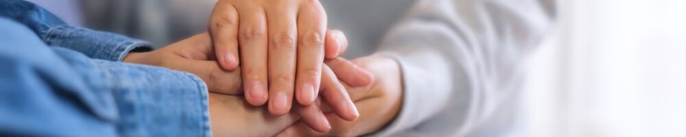 two people holding hands in a supportive and comforting manner